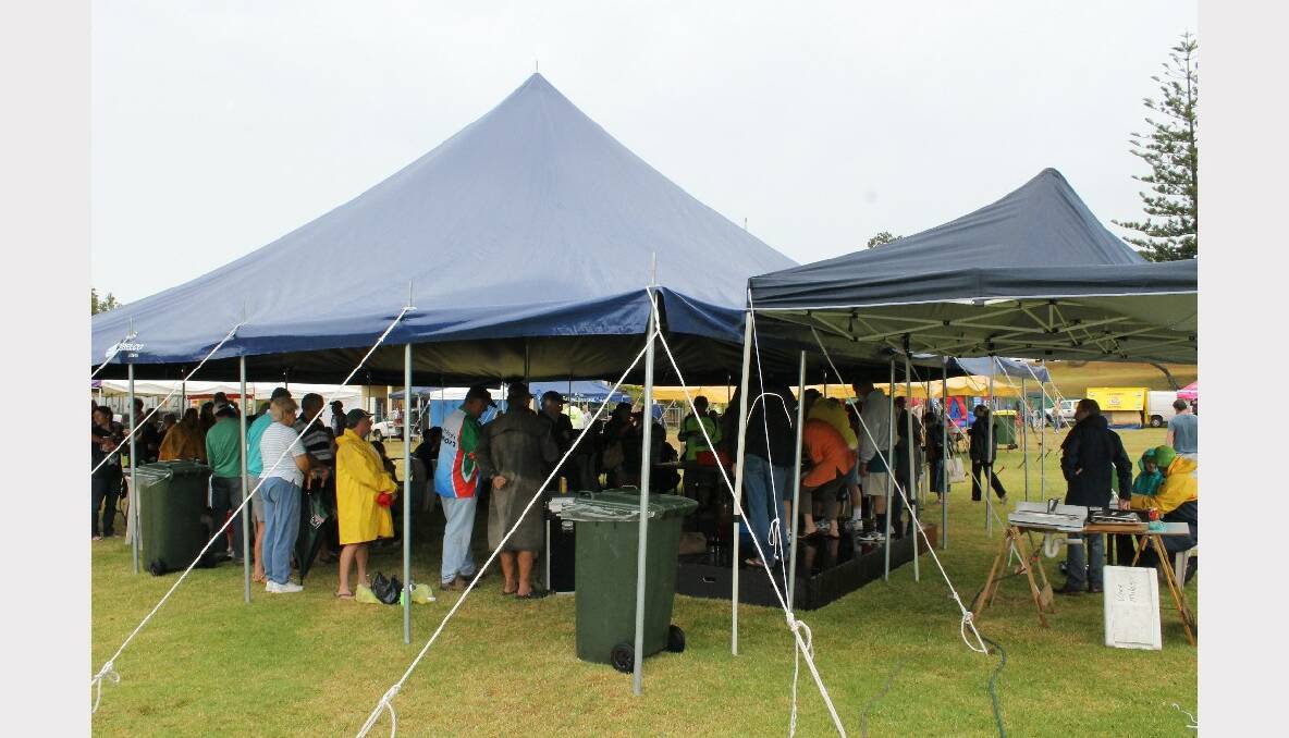 The rain had people huddle under the marquees at the Straddie Oyster Festival at Dunwich 