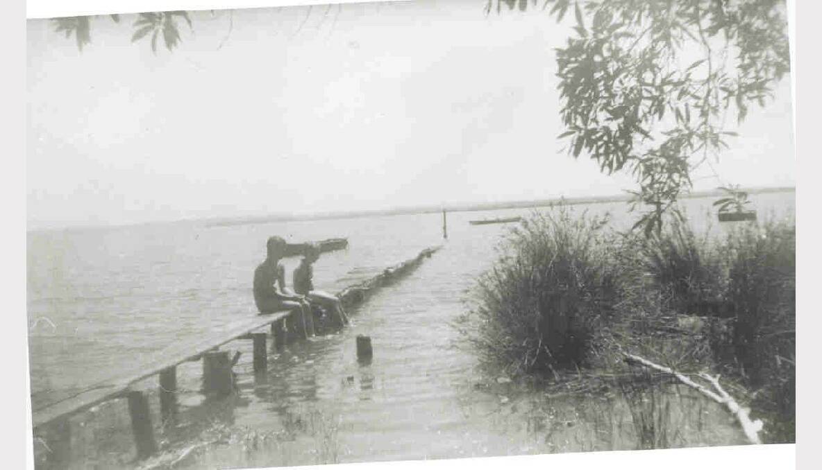 A little jetty was in Redland Bay. It was for the owner’s boat, and for children who fished and swam off it. Note how narrow and low it is compared with the bigger public jetties. There were many jetties like this one in the Redlands. The photo was taken in about 1959.