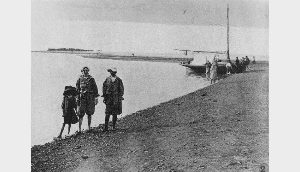 Visitors, wearing pantaloons and bonnets, take a stroll along the beach on King Island in 1939. Photo: Courtesy of SEQ Catchments.